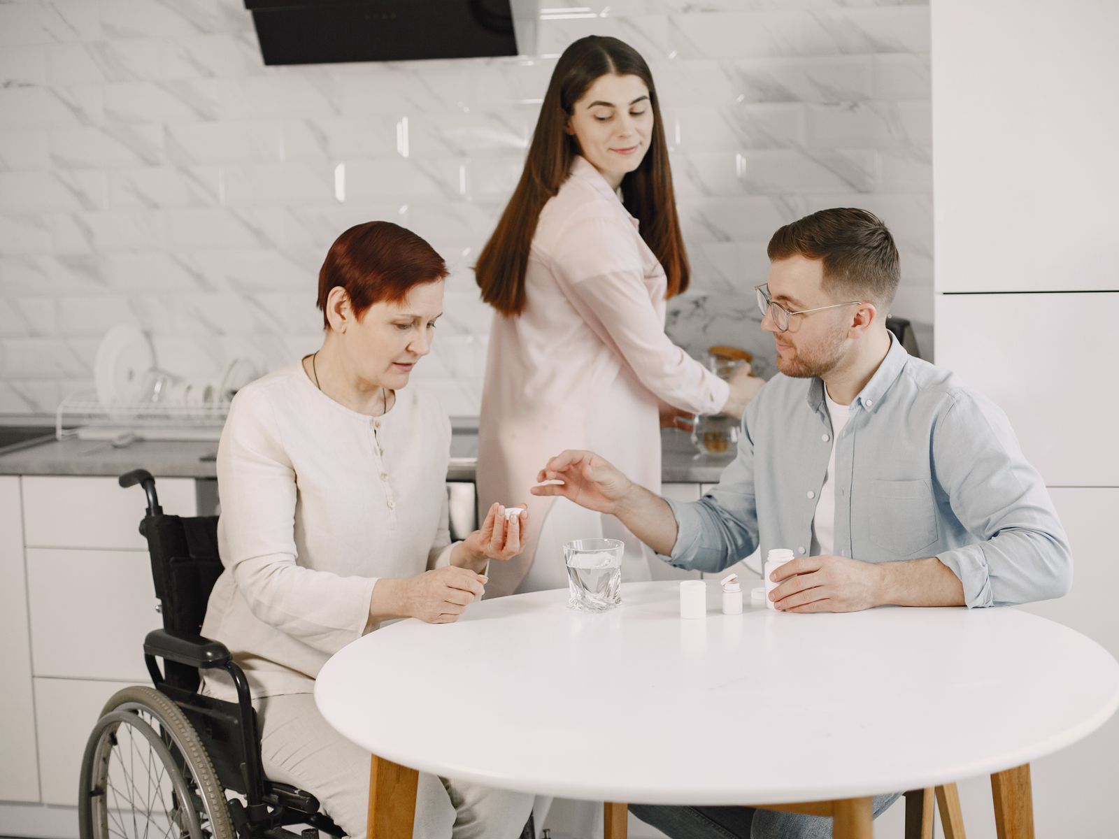 A small group meeting around a table, including a wheelchair user